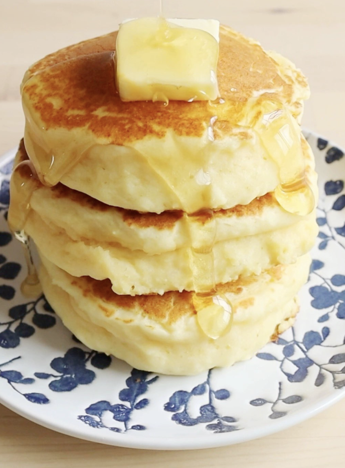 3段に積み重なったふかふかのパンケーキの写真です。バターと蜂蜜がかかっていて、美味しそうです。